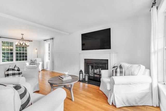 12 Blueberry Ln, Hudson, MA 01749 - living room with a chandelier, light wood-style flooring, and a fireplace with flush hearth