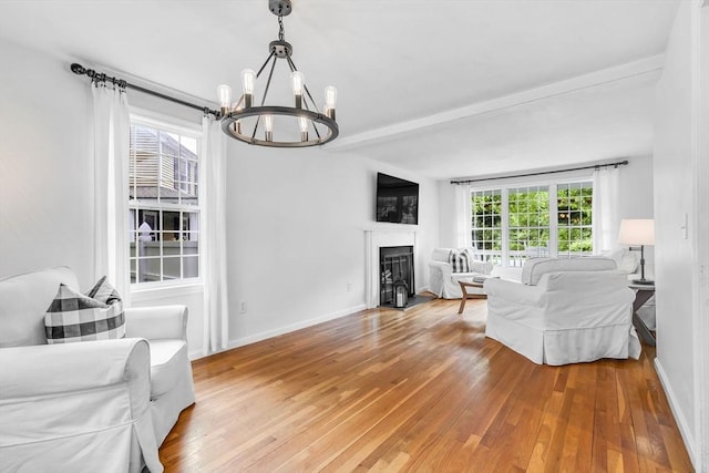 12 Blueberry Ln, Hudson, MA 01749 - living area featuring a chandelier, light wood-type flooring, a fireplace, beam ceiling, and baseboards