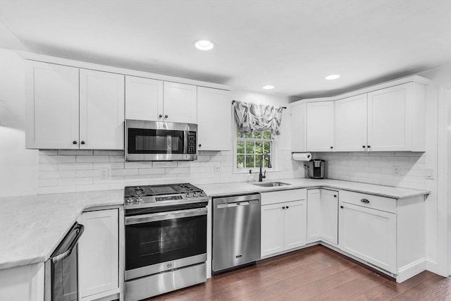 12 Blueberry Ln, Hudson, MA 01749 - kitchen with appliances with stainless steel finishes, a sink, white cabinetry, dark wood-type flooring, and tasteful backsplash