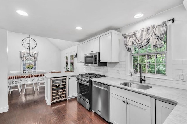 12 Blueberry Ln, Hudson, MA 01749 - kitchen featuring stainless steel appliances, a sink, beverage cooler, a peninsula, and white cabinetry