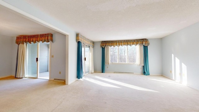 carpeted spare room featuring a baseboard radiator and a textured ceiling