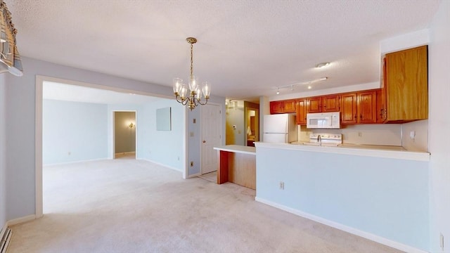 kitchen with white appliances, light carpet, decorative light fixtures, kitchen peninsula, and a chandelier