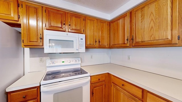 kitchen featuring white appliances and a textured ceiling