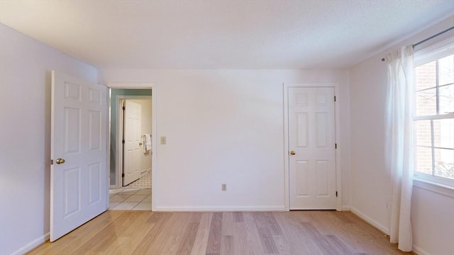 empty room featuring a healthy amount of sunlight and light hardwood / wood-style floors