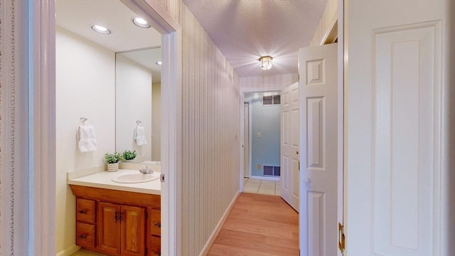 corridor with sink and light hardwood / wood-style flooring