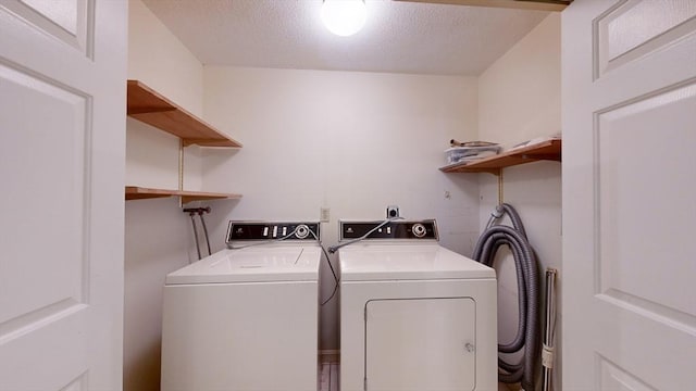 laundry room featuring washer and dryer and a textured ceiling