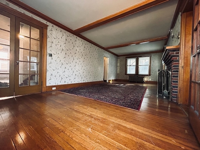 unfurnished living room with dark hardwood / wood-style floors, radiator, beamed ceiling, ornamental molding, and a fireplace