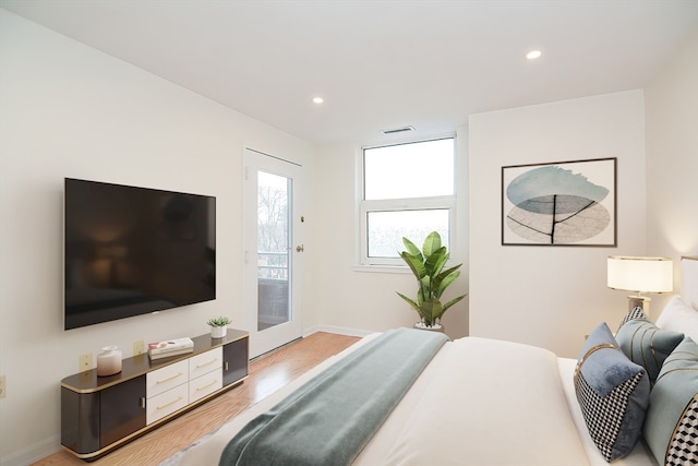 bedroom with access to exterior and light hardwood / wood-style floors