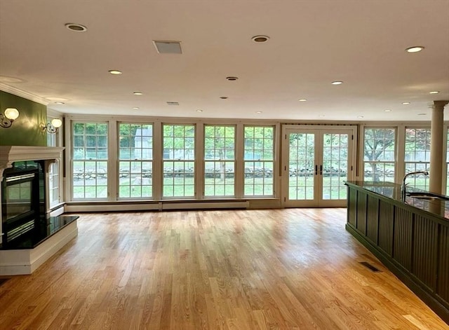 14 Alderbrook Dr, Topsfield, MA 01983 - unfurnished living room with a sink, a glass covered fireplace, light wood-type flooring, recessed lighting, and french doors