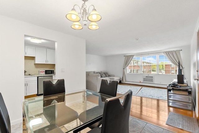 9 Tara Dr Unit 8, Weymouth, MA 02188 - dining room featuring a chandelier, baseboards, an AC wall unit, and light wood finished floors