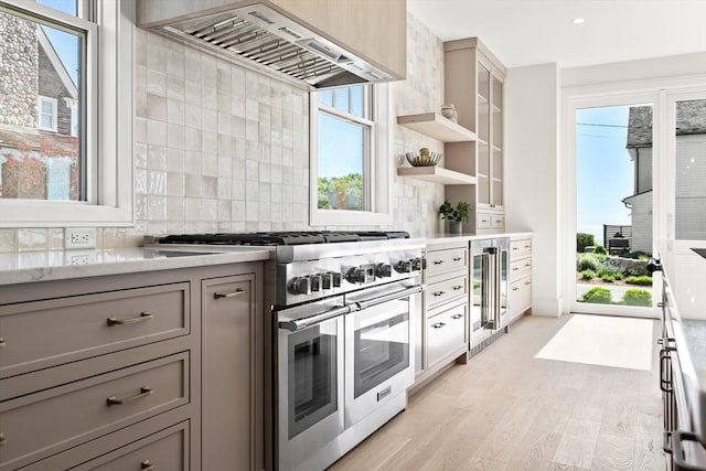 2 Collier Rd, Scituate, MA 02066 - kitchen featuring range with two ovens, gray cabinetry, wall chimney exhaust hood, beverage cooler, and light wood-type flooring