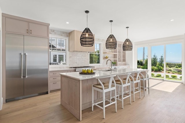 2 Collier Rd, Scituate, MA 02066 - kitchen with built in refrigerator, light wood-style floors, light countertops, an island with sink, and plenty of natural light