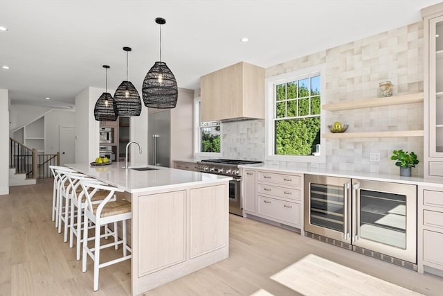 2 Collier Rd, Scituate, MA 02066 - kitchen featuring stainless steel appliances, beverage cooler, a sink, light wood finished floors, and light countertops