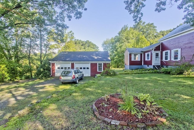 view of green lawn with an outbuilding and a detached garage