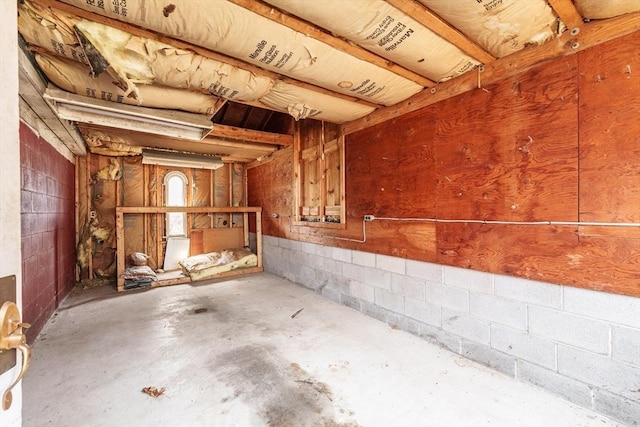 miscellaneous room featuring concrete floors and concrete block wall