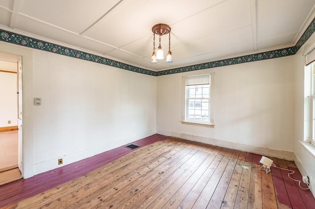 spare room featuring hardwood / wood-style flooring and baseboards