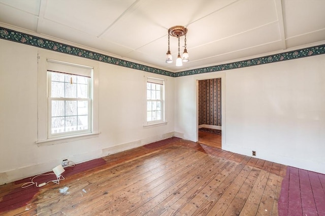 empty room with hardwood / wood-style flooring, plenty of natural light, and baseboards