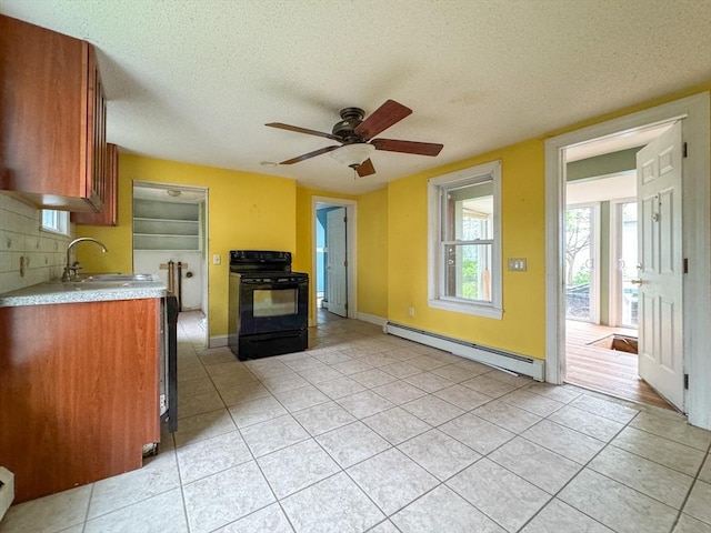 66 Taylor St, Holyoke, MA 01040 - kitchen featuring black / electric stove, a baseboard radiator, a sink, light tile patterned flooring, and a textured ceiling