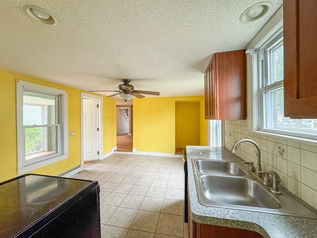 66 Taylor St, Holyoke, MA 01040 - kitchen featuring a sink, a textured ceiling, baseboard heating, backsplash, and light tile patterned flooring