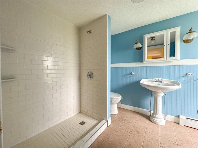 66 Taylor St, Holyoke, MA 01040 - bathroom with a stall shower, toilet, tile patterned flooring, wainscoting, and baseboard heating