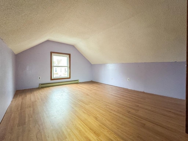 66 Taylor St, Holyoke, MA 01040 - additional living space with baseboard heating, wood finished floors, a textured ceiling, and lofted ceiling