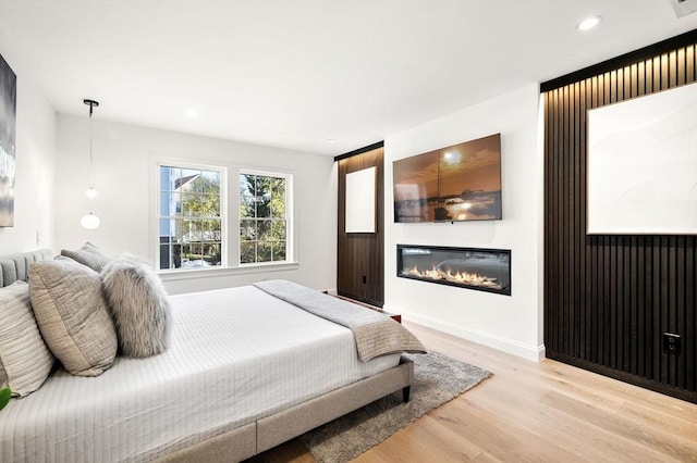 238 Bellevue St Unit 2, Newton, MA 02458 - bedroom featuring wood finished floors, a glass covered fireplace, recessed lighting, and baseboards