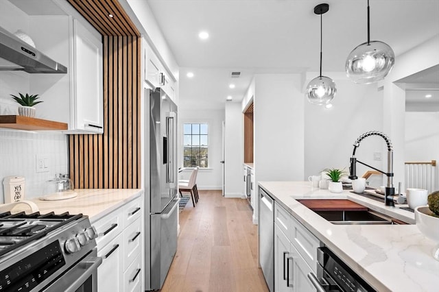238 Bellevue St Unit 2, Newton, MA 02458 - kitchen featuring a sink, appliances with stainless steel finishes, wall chimney exhaust hood, white cabinetry, and light wood finished floors
