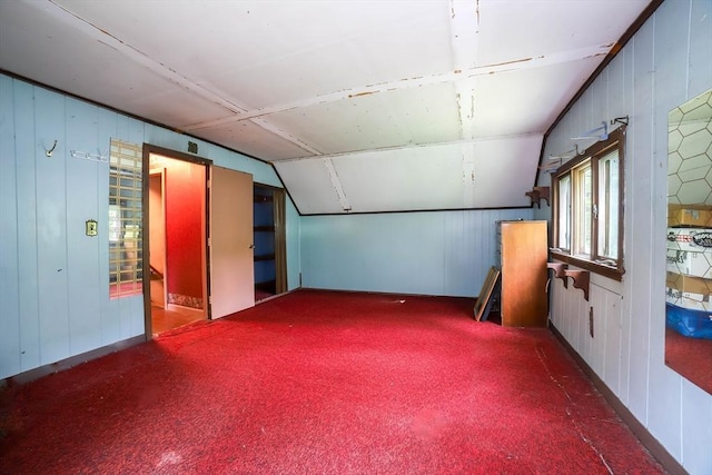 213 Nashua Rd, Billerica, MA 01862 - additional living space with carpet floors, vaulted ceiling, wood walls, and a decorative wall