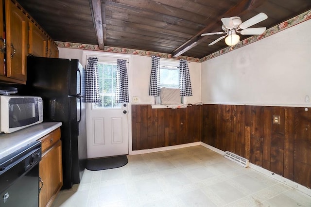 213 Nashua Rd, Billerica, MA 01862 - kitchen with black appliances, a wooden ceiling with exposed beams, a wainscoted wall, light flooring, and ceiling fan