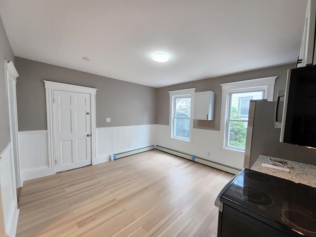 97-99 Blaisdell St Unit 1, Haverhill, MA 01832 - unfurnished living room featuring a wainscoted wall, light wood finished floors, and a baseboard radiator