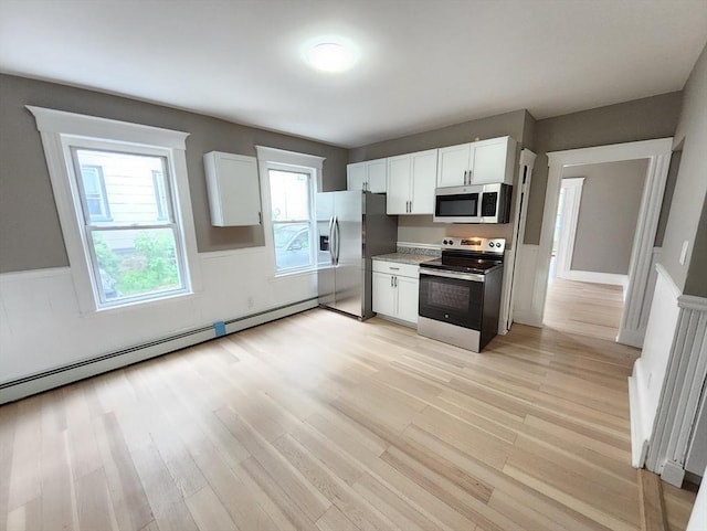 97-99 Blaisdell St Unit 1, Haverhill, MA 01832 - kitchen featuring appliances with stainless steel finishes, light wood-type flooring, white cabinetry, and a baseboard heating unit