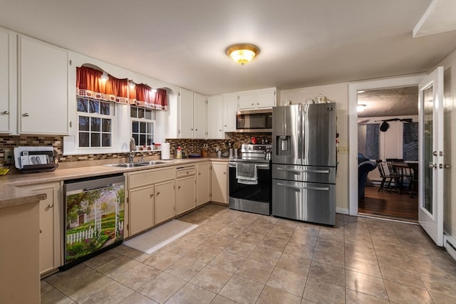 kitchen with tasteful backsplash, appliances with stainless steel finishes, sink, and light tile patterned floors