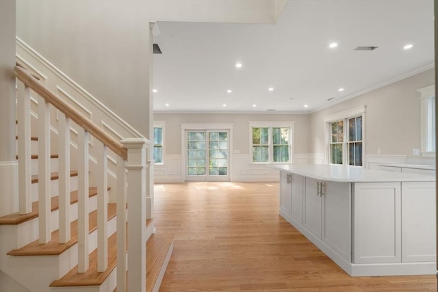 23 Francis Unit 23, Newton, MA 02459 - hallway featuring ornamental molding, a decorative wall, light wood-style flooring, stairway, and a wainscoted wall