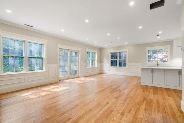 23 Francis Unit 23, Newton, MA 02459 - unfurnished living room with crown molding, a decorative wall, wainscoting, recessed lighting, and light wood finished floors