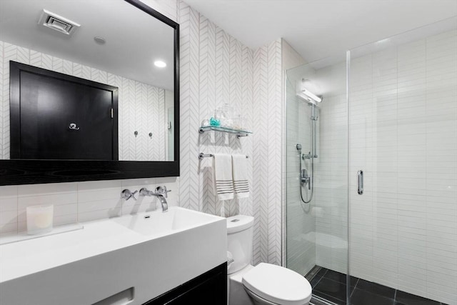 full bathroom with tile walls, visible vents, toilet, a shower stall, and tile patterned floors