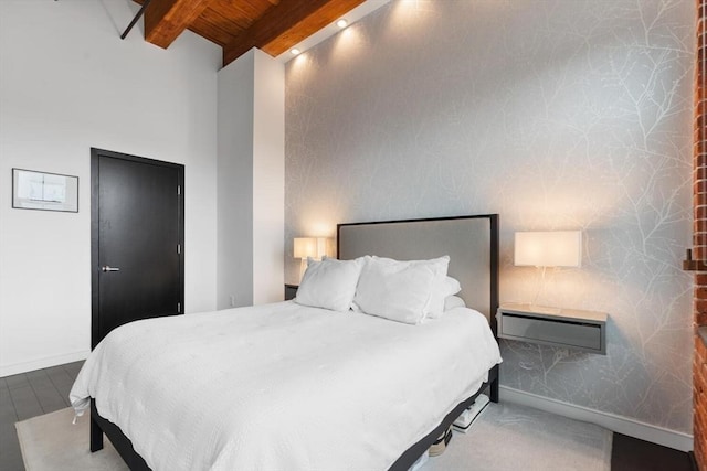 bedroom with beamed ceiling, wood ceiling, and baseboards