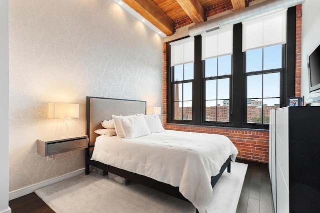 bedroom with wooden ceiling, wood finished floors, baseboards, beam ceiling, and wallpapered walls