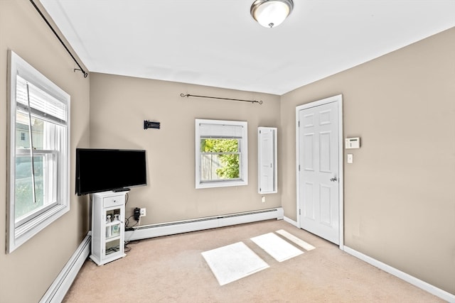 interior space featuring plenty of natural light, light carpet, and a baseboard heating unit