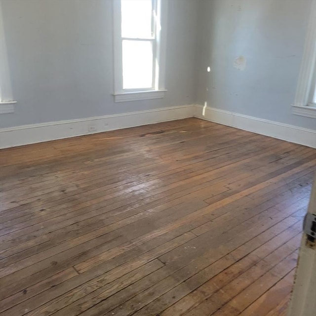 spare room with dark wood-style floors and baseboards