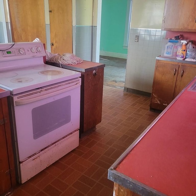 kitchen featuring brick floor and white electric range oven