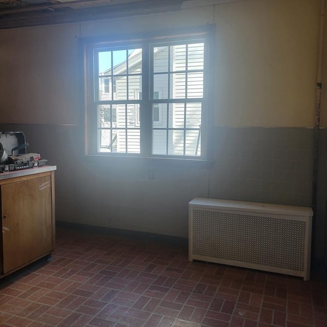 interior space featuring brick floor and radiator