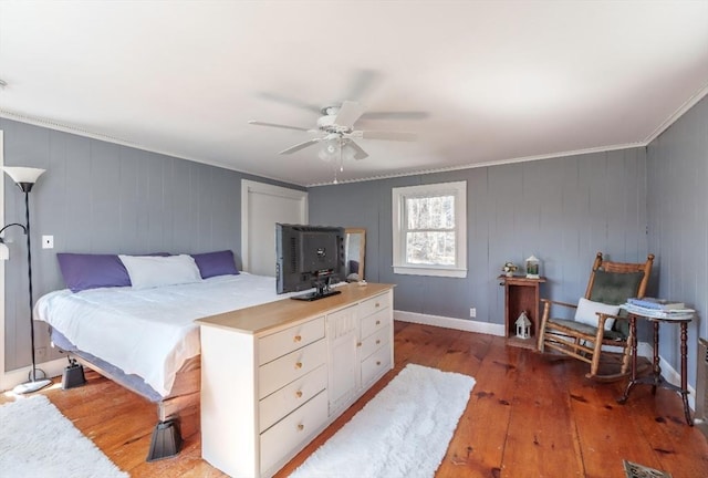 bedroom with wood-type flooring, crown molding, and a ceiling fan