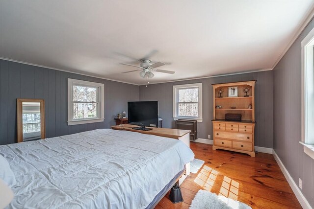 bedroom featuring ornamental molding, light wood-style flooring, and a ceiling fan