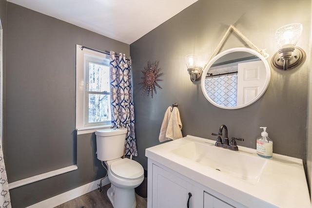 bathroom with vanity, baseboards, toilet, and wood finished floors