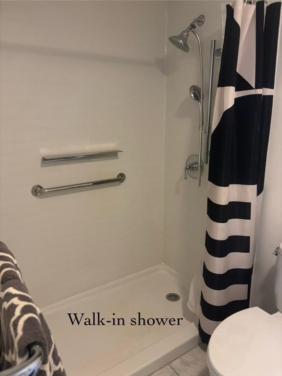 full bathroom with a shower stall and toilet