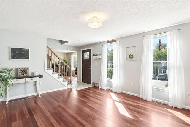 23 Jasmine Ct, Dracut, MA 01826 - entrance foyer with wood finished floors, stairway, a textured ceiling, and baseboards