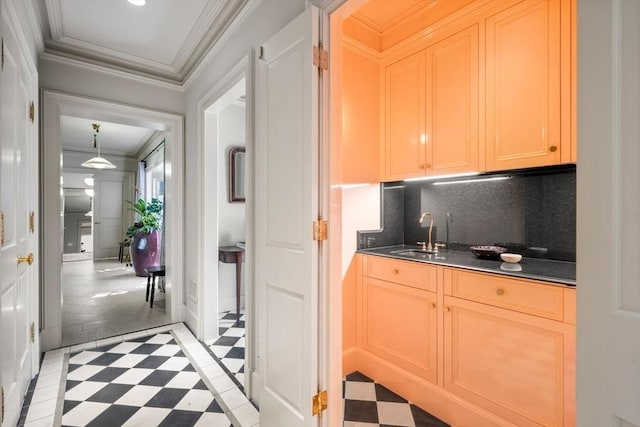 interior space featuring sink, crown molding, and backsplash