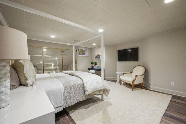 bedroom with dark hardwood / wood-style flooring and a drop ceiling