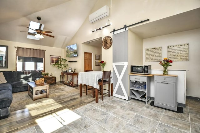 living room featuring a wall unit AC, high vaulted ceiling, ceiling fan, and a barn door