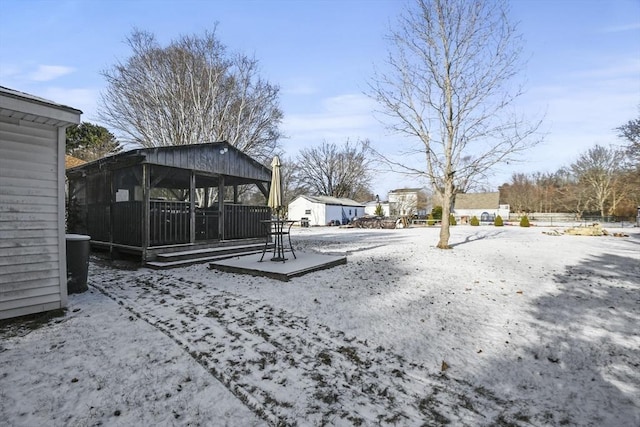 yard covered in snow featuring a sunroom